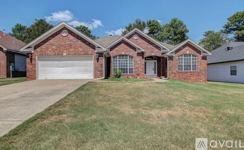 A brick house with a white garage door and a brown roof.