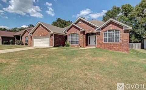 A house with a red brick exterior and a white garage door is for sale.