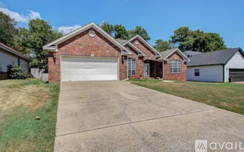 A house with a brick facade and a white garage door is for sale.