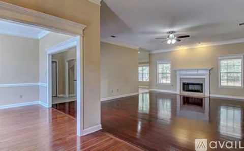 A spacious room with wood flooring and a fireplace.