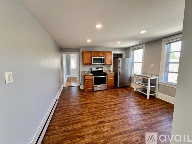 A kitchen with wooden floors and white walls.