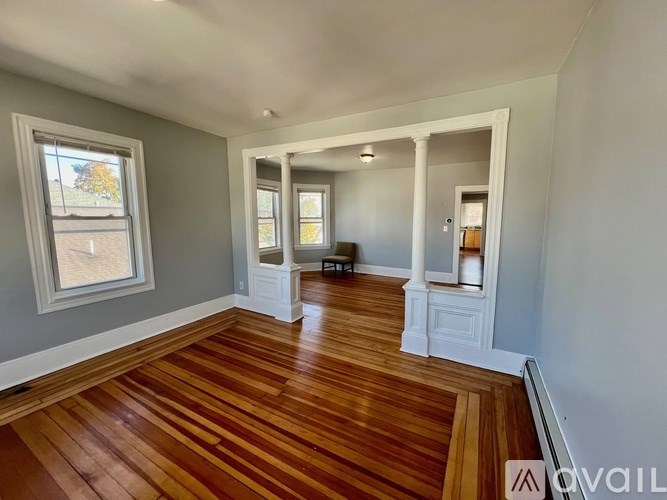A room with wooden floors and white columns.