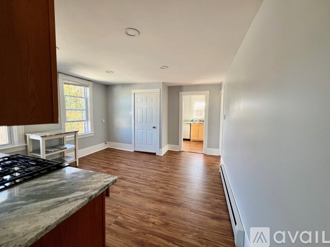 A kitchen with a marble countertop and wooden floors.