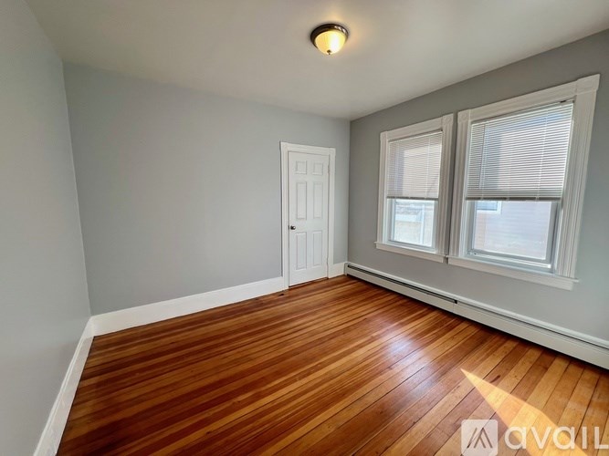 A room with wooden flooring and a white door.