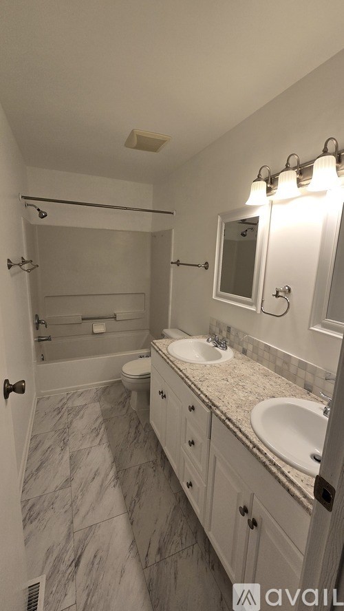 A bathroom with a marble floor and a sink with a mirror above it.