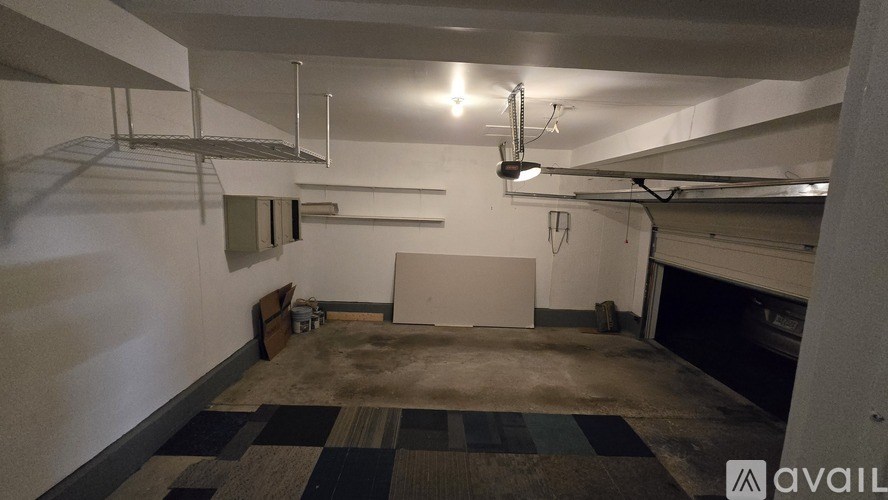 A large empty room with a checkered floor and a white wall.