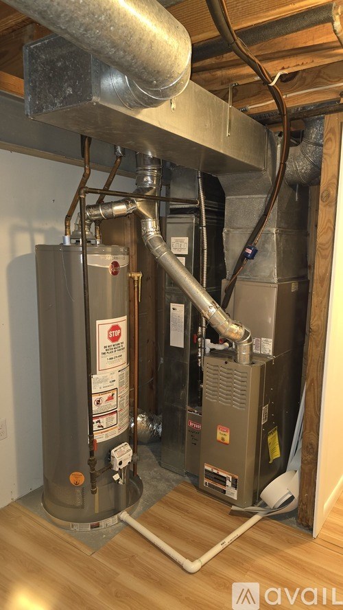 A heating system with a grey boiler and a white pipe.