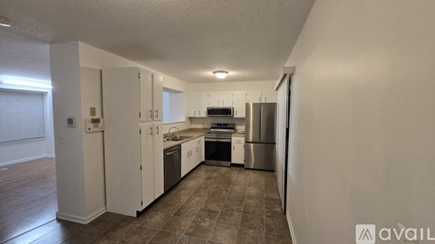 A kitchen with white cabinets and a stainless steel refrigerator.