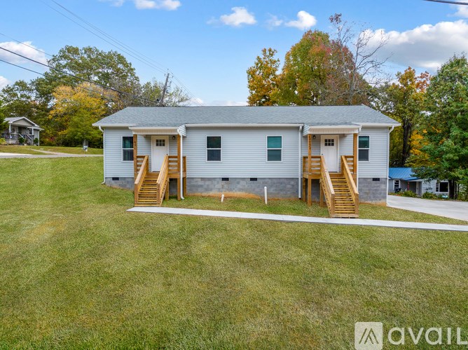 A two-story house with a porch and stairs leading to the front door.