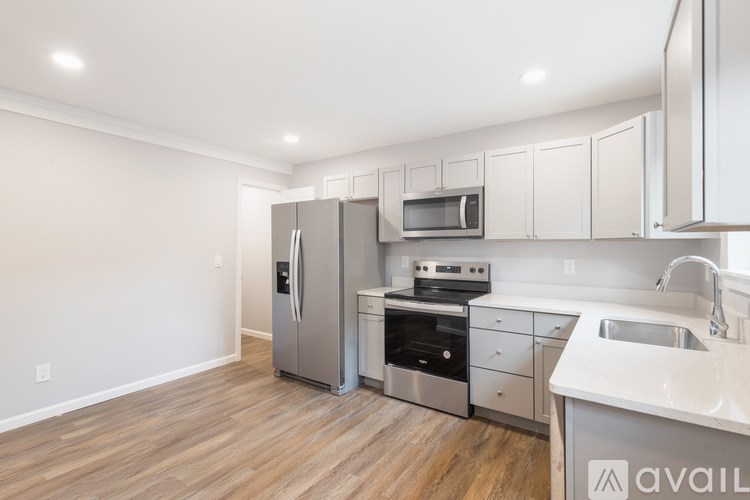 A kitchen with a refrigerator, oven, and sink.