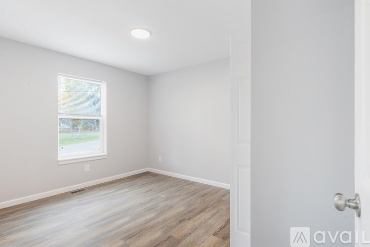 A room with a window and wooden flooring.