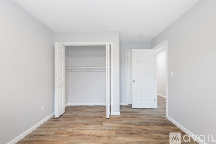 A room with a white door and a white closet with a shelf.