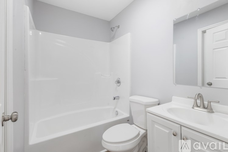 A white bathroom with a toilet, sink, and bathtub.