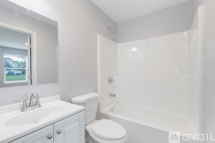 A white bathroom with a toilet, sink, and bathtub.