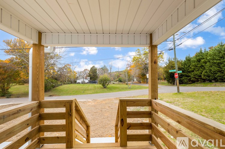 A porch with a view of a road and trees.