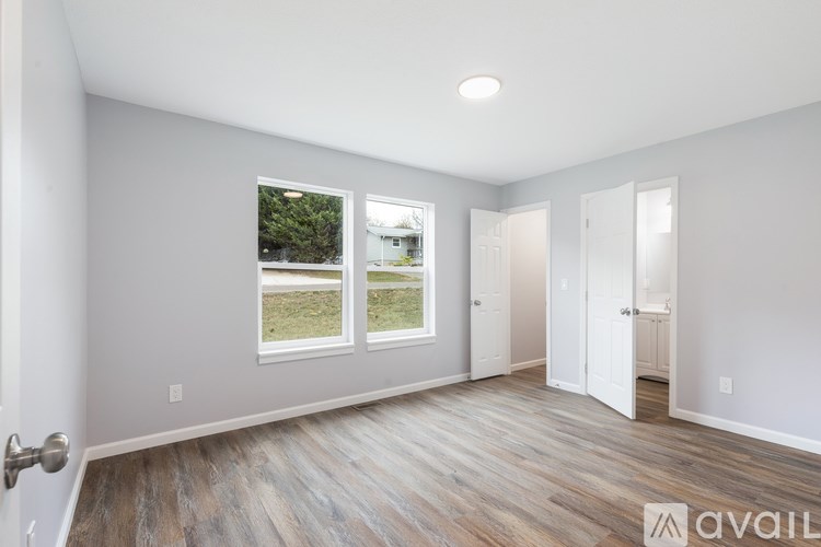 A room with a wooden floor and a window showing an outdoor view.