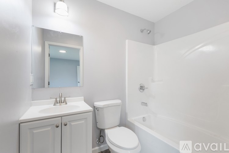 A white bathroom with a toilet, sink, and bathtub.