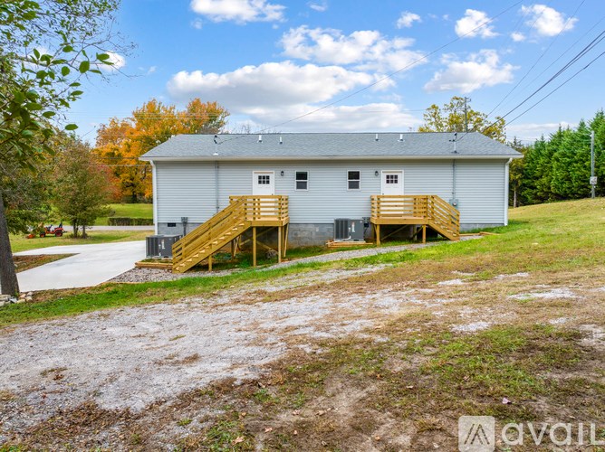 A house with a grey roof and a wooden staircase leading to the front door.