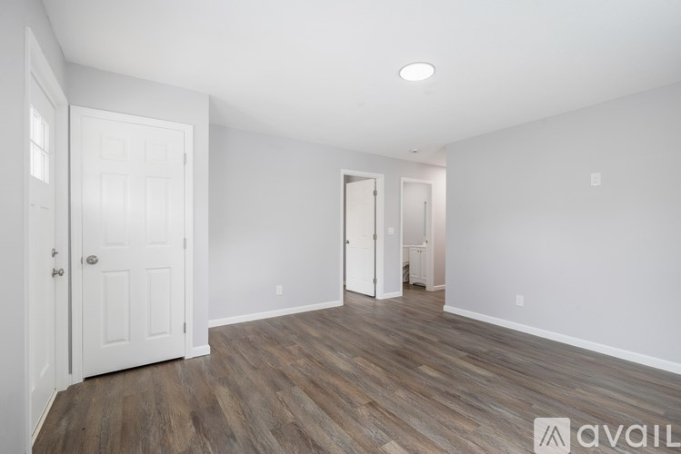 A room with wooden flooring and white walls.