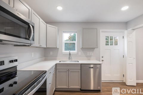 A kitchen with white cabinets and stainless steel appliances.