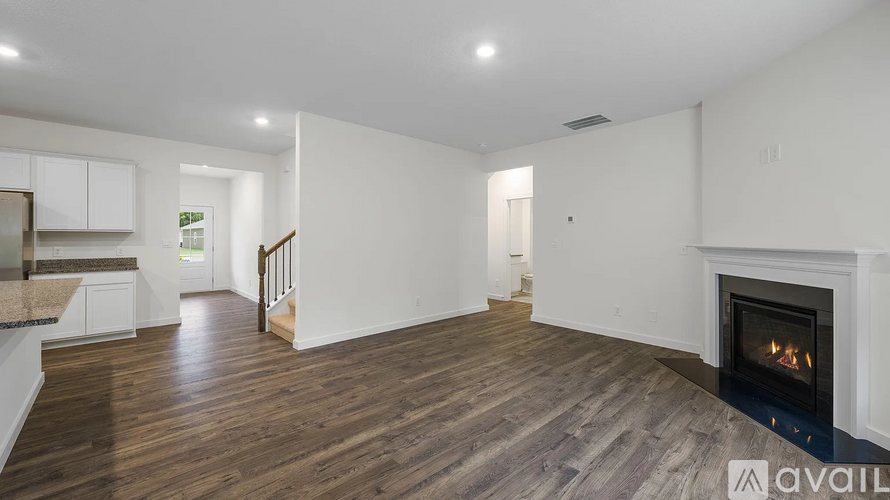 A spacious living room with a fireplace and hardwood floors.