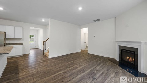 A spacious living room with a fireplace and hardwood floors.