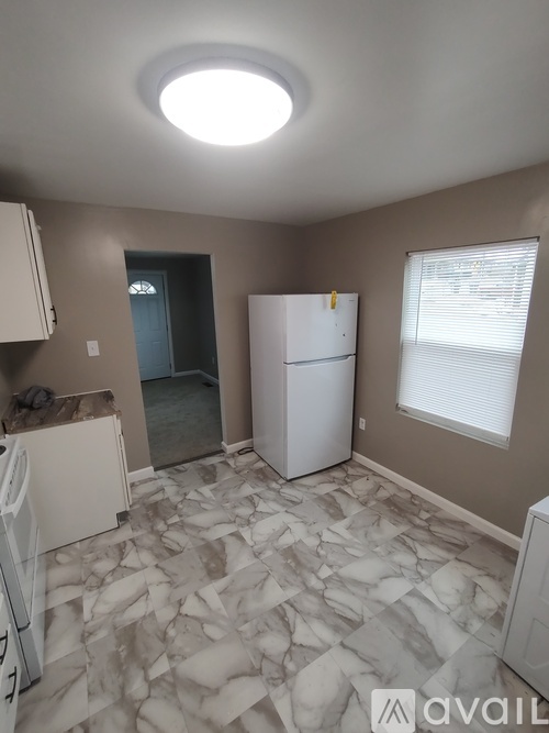 A kitchen with a white fridge and a white dishwasher.