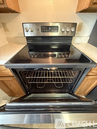 A bathroom with a toilet, sink, and wooden cabinets.