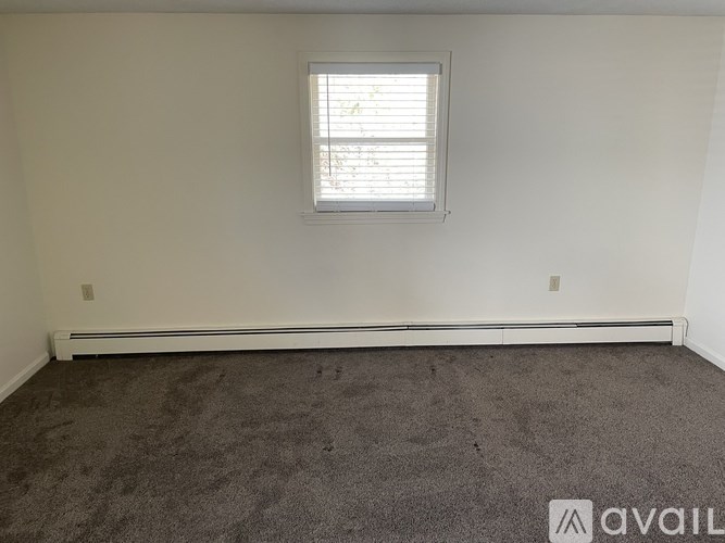 A room with a window and carpeted floor.