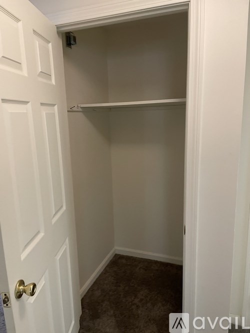 A white door with a gold handle and a small black camera above it.