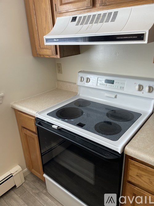 A white oven with a stove top and a white range hood above it.