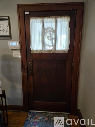 A brown door with a window and a sign on the wall.