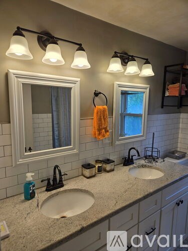 A bathroom with a sink, mirror, and light fixture.