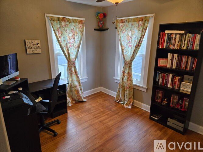 A room with a desk, chair, and bookshelf.