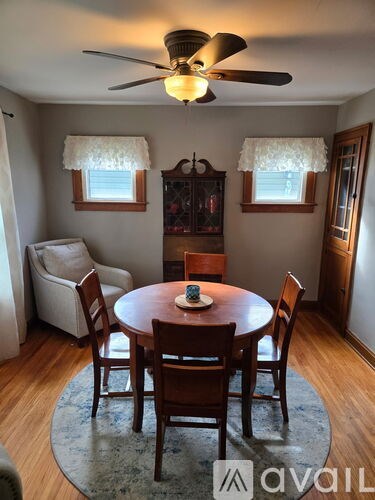 A dining room with a table set for two and a fan.