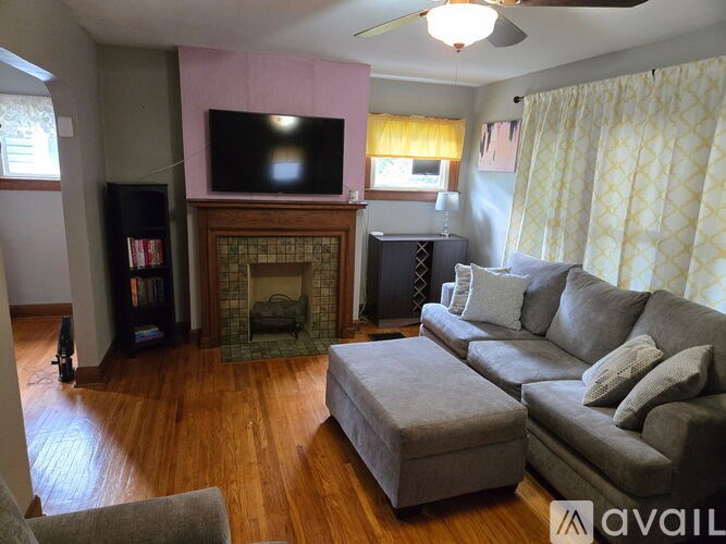 A living room with a grey couch and a fireplace.