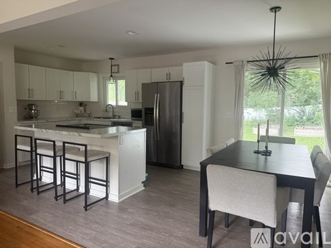 A modern kitchen with white cabinets and a black dining table.