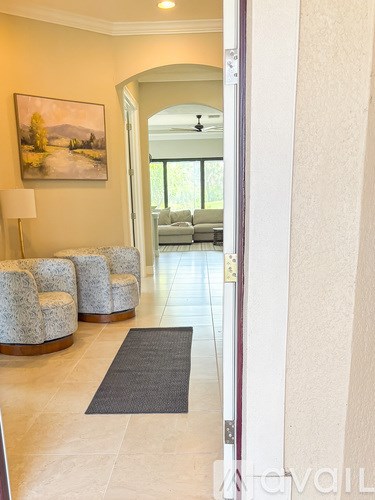 A hallway with a grey rug and a painting on the wall.
