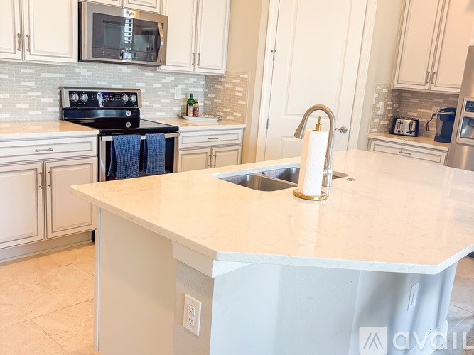 A kitchen with a white countertop and a black stove.