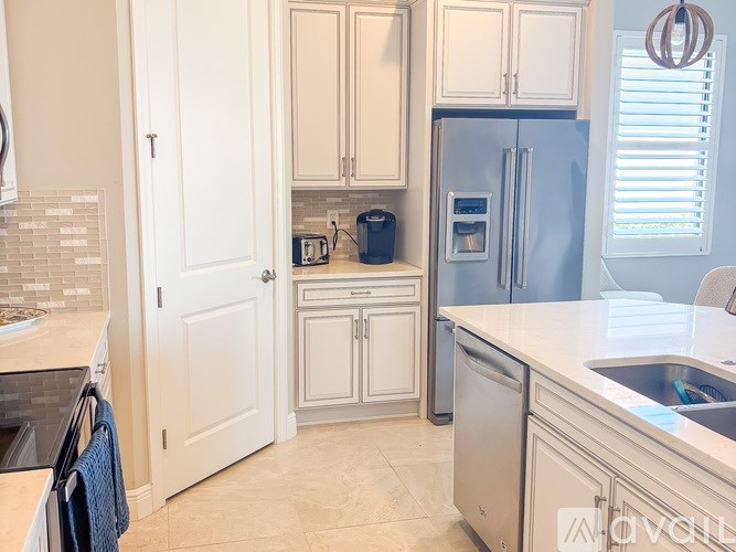 A kitchen with a blue refrigerator and white cabinets.