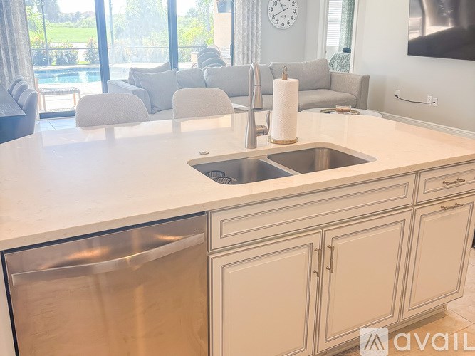A kitchen with a stainless steel dishwasher and a white countertop.