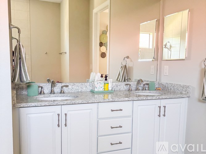 A bathroom with two sinks and a large mirror.