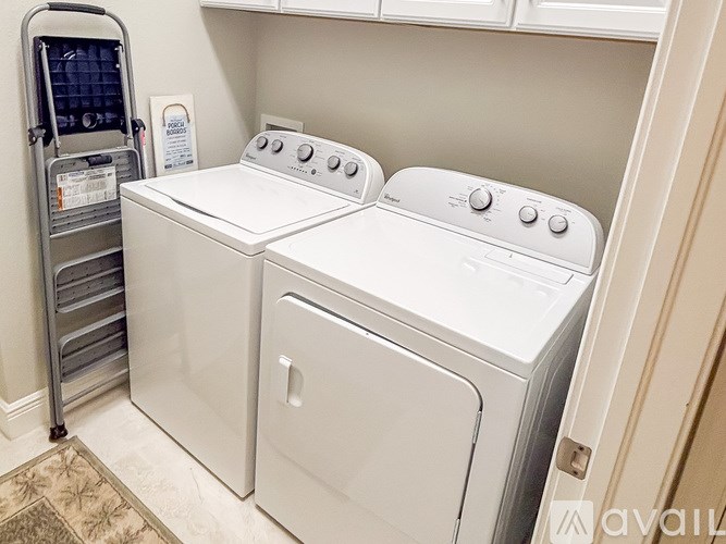 A washer and dryer are in a small laundry room.