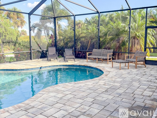 A pool surrounded by a glass wall and wooden chairs.