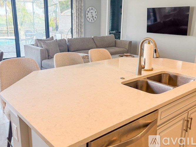 A kitchen with a large island and a clock on the wall.