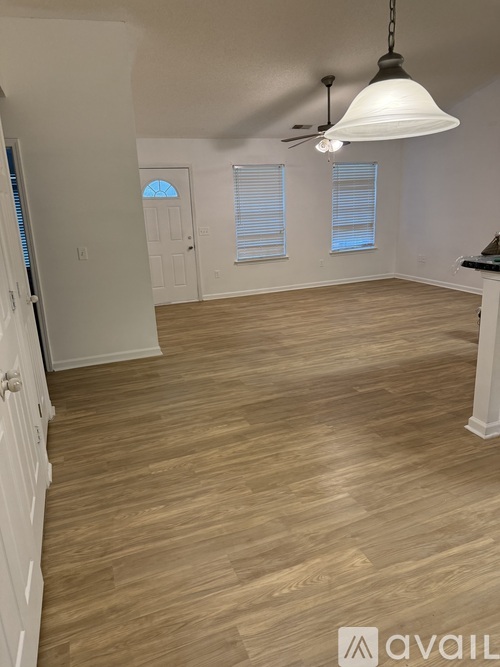 A room with wooden flooring and a ceiling fan.