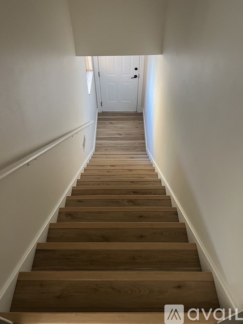 A long flight of wooden stairs leads to a door at the top.