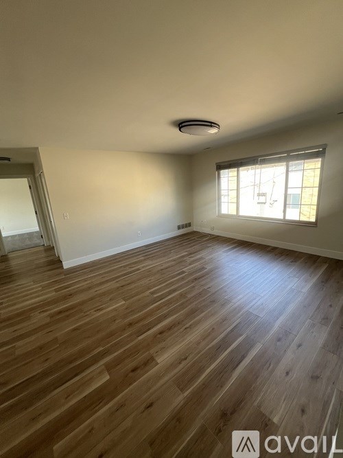 A room with wooden flooring and a window.