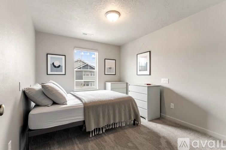 A bedroom with a bed, dresser, and two pictures on the wall.