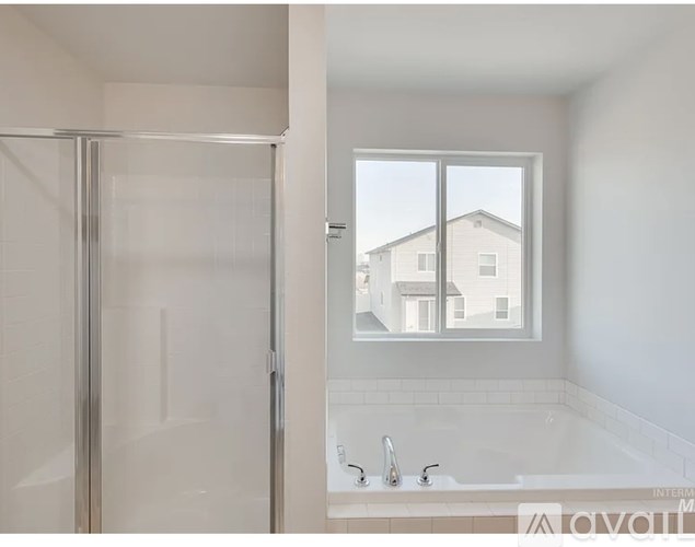 A bathroom with a glass shower door and a tub with a faucet.